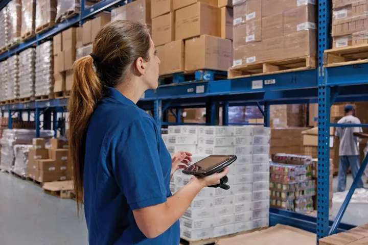 Operaria revisando inventario en un almacén